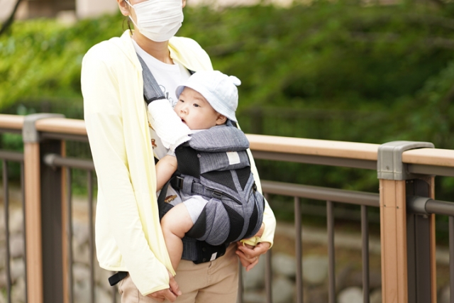 赤ちゃんを抱っこ紐で抱っこするママ